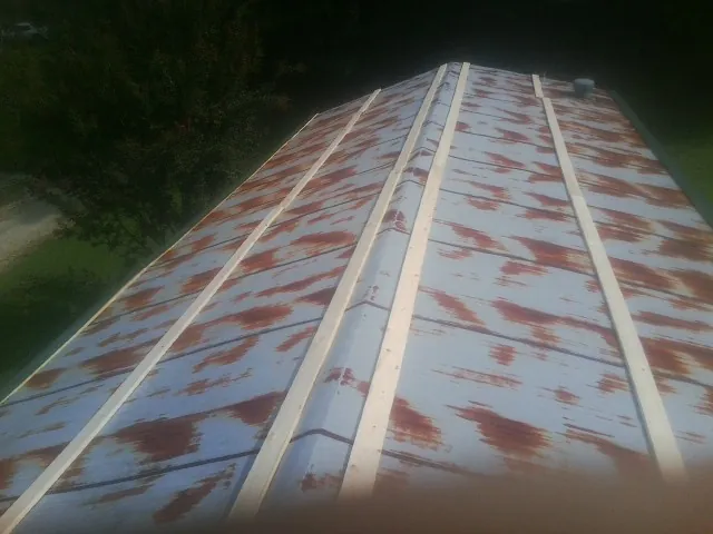 Rusted metal roof panels with new wood purlins before replacement — Storm Damage Roof Repair in Albertson by Roofing Brothers