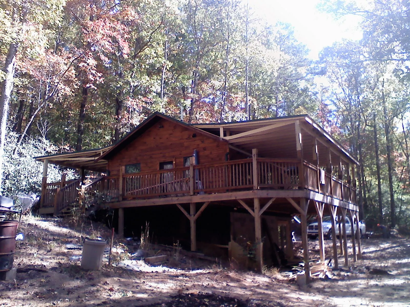 Log cabin with a wraparound porch and metal roof in the fall in Albertson