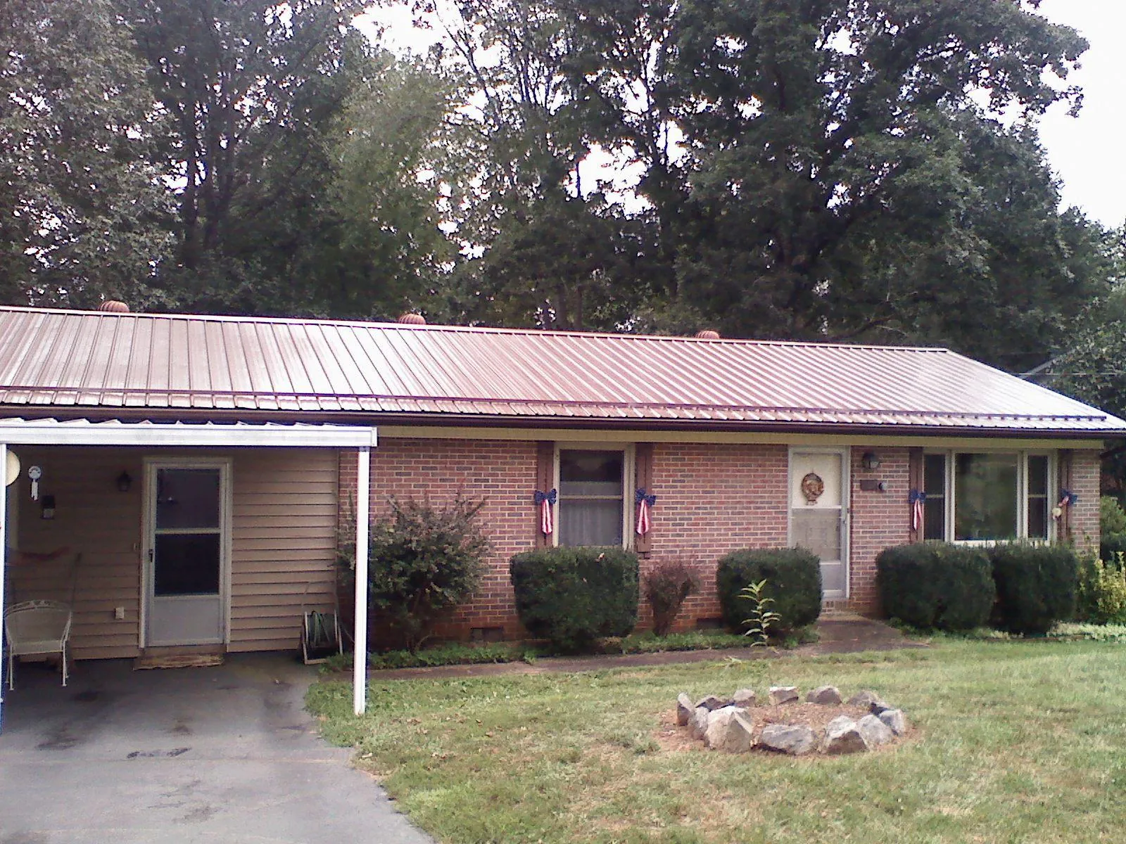 Bronze metal roof and carport on a brick ranch home — Roof Repair work by our crew in Albertson